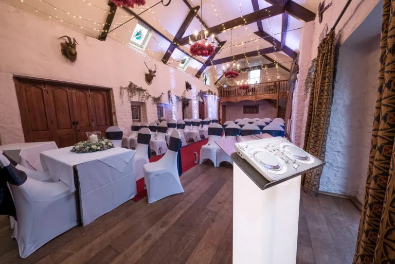 Wedding aisle with ceremony music playing. Elegant wedding DJ setup in white.