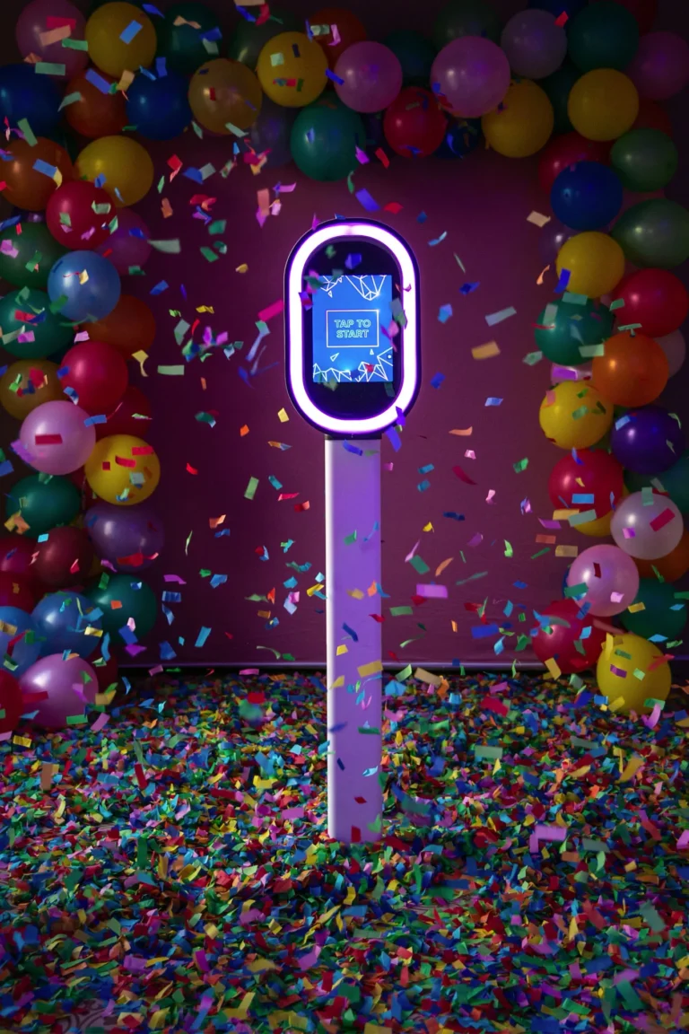 Salsa photo booth pod setup at a wedding party. The pod is surrounded by coloured balloons and confetti.