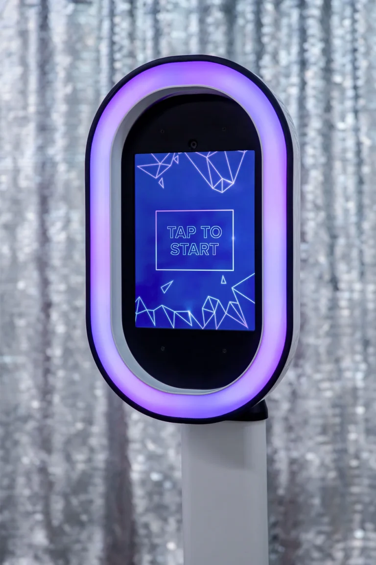 Salsa photo booth pod displays customisable RGB light. A shimmer wall at a wedding reception is setup in the background.